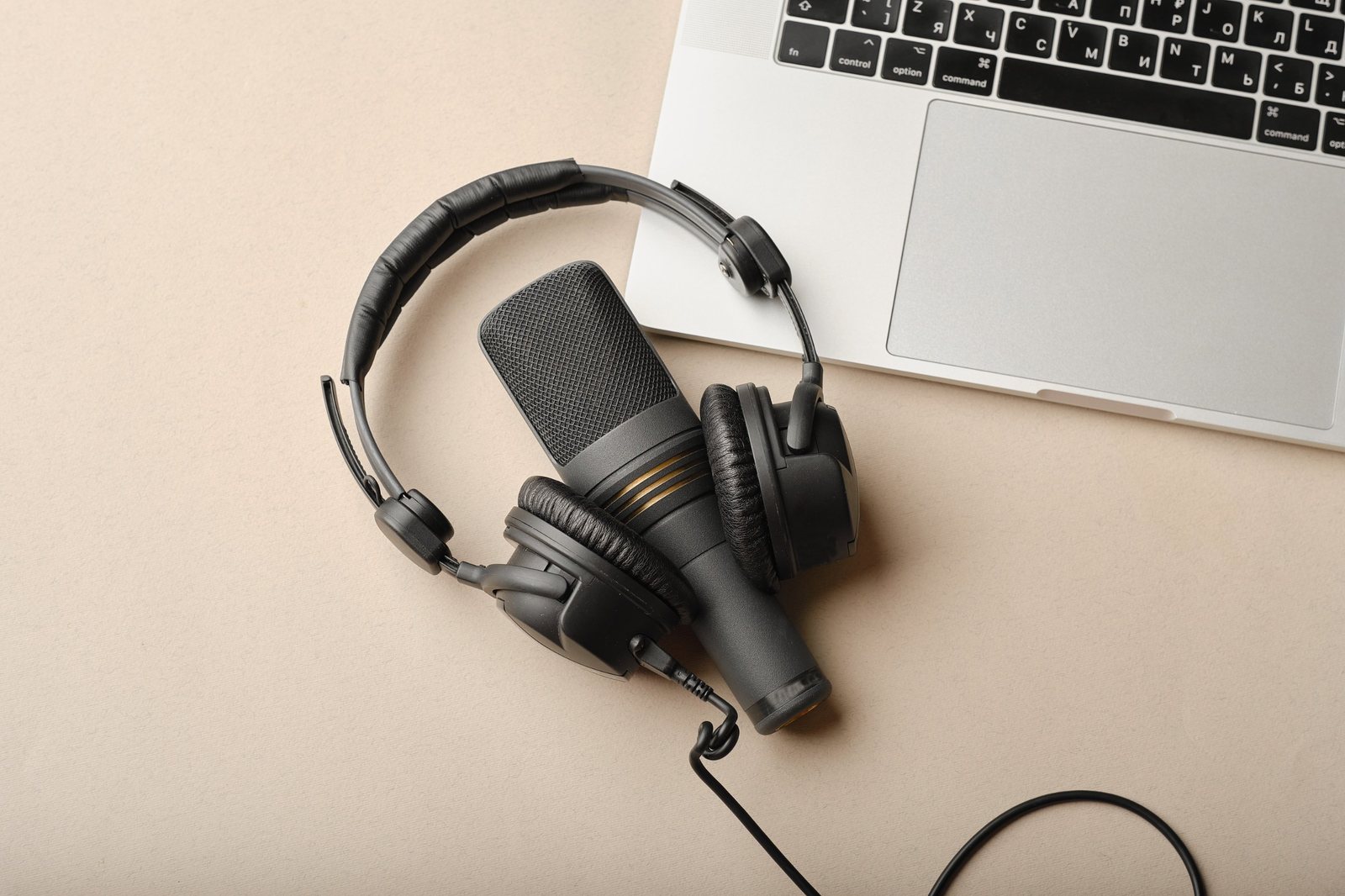 Studio microphone and headphones next to a laptop